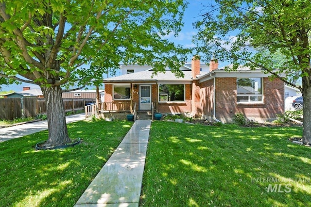 view of front of home with brick siding, a chimney, and solar panels