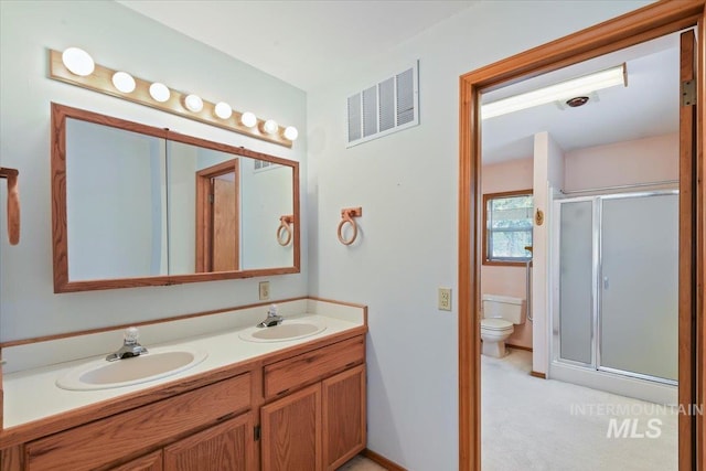 full bath with a stall shower, toilet, and double vanity