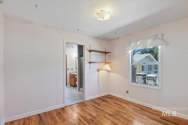 unfurnished room with light wood finished floors and baseboards