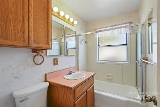 bathroom with vanity, bath / shower combo with glass door, and toilet
