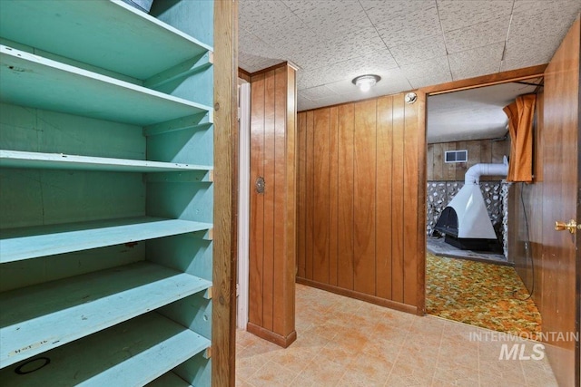 hallway featuring wood walls