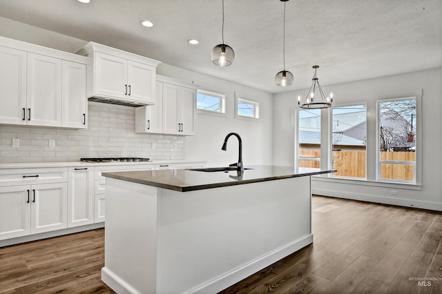 kitchen with dark wood-type flooring, backsplash, a wealth of natural light, and a sink