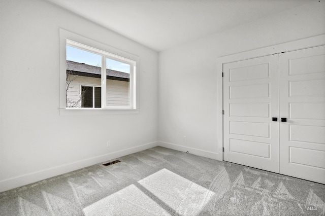 unfurnished room featuring visible vents, baseboards, and carpet