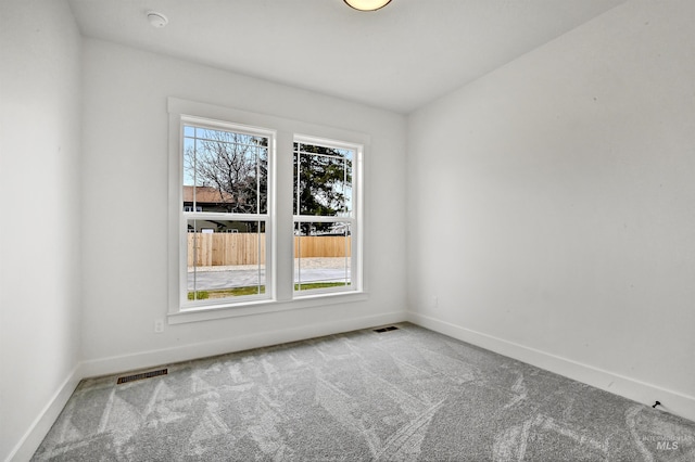 carpeted empty room with baseboards and visible vents