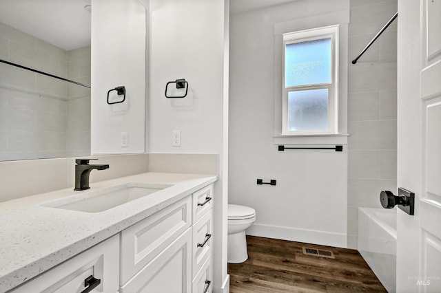 full bath featuring visible vents, toilet, wood finished floors, baseboards, and vanity