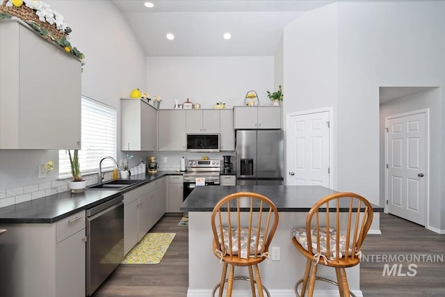 19339 Susquehanna Way, Caldwell, ID 83605 - kitchen with appliances with stainless steel finishes, dark countertops, a breakfast bar, a sink, and a high ceiling