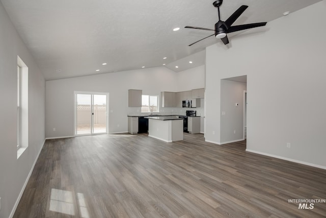19339 Susquehanna Way, Caldwell, ID 83605 - unfurnished living room featuring recessed lighting, baseboards, ceiling fan, high vaulted ceiling, and wood finished floors
