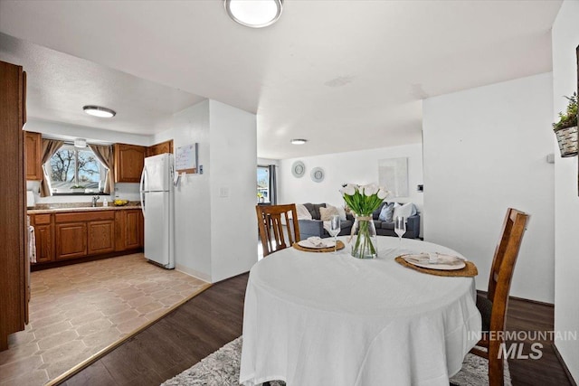 dining space featuring plenty of natural light, light hardwood / wood-style flooring, and sink