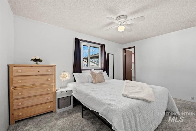 carpeted bedroom with a textured ceiling and ceiling fan