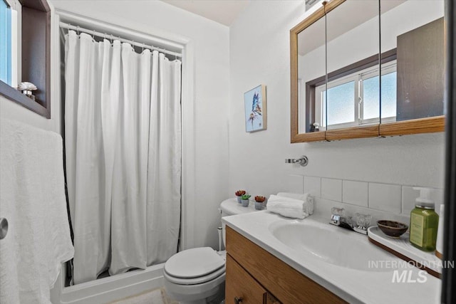 bathroom with toilet, vanity, and curtained shower