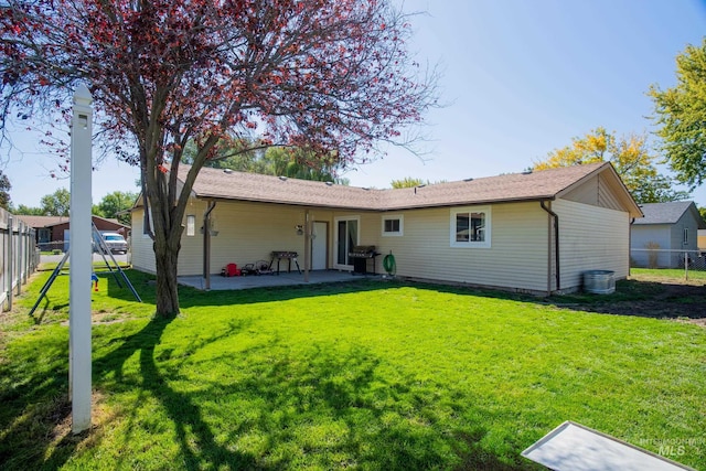 rear view of property with a yard and a patio