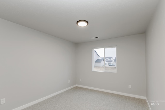 unfurnished room with light carpet and baseboards