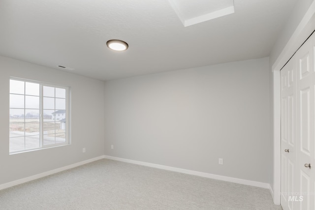 unfurnished bedroom featuring light colored carpet, a closet, and baseboards
