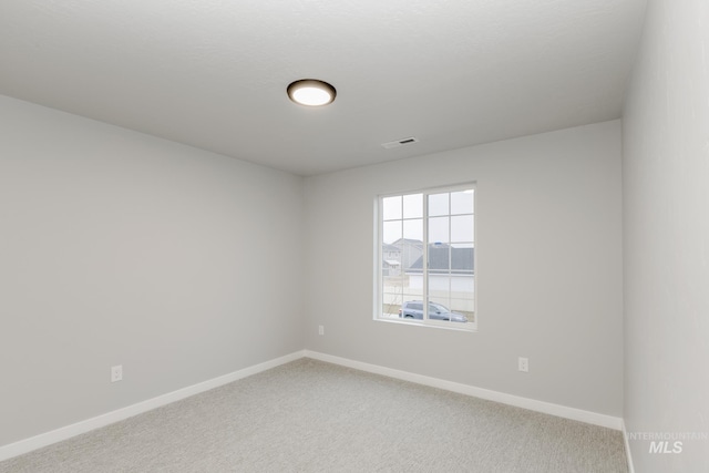 unfurnished room with light colored carpet, baseboards, and visible vents