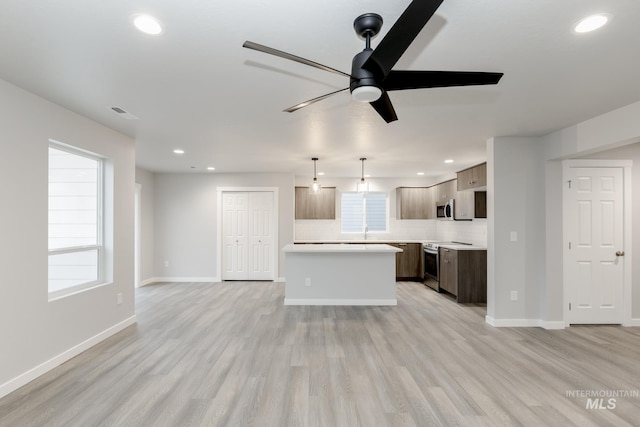 kitchen featuring light wood-style floors, ceiling fan, light countertops, appliances with stainless steel finishes, and recessed lighting