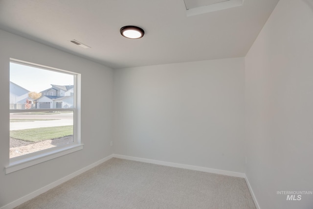 empty room featuring light colored carpet and baseboards