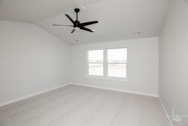 carpeted empty room featuring a ceiling fan, lofted ceiling, baseboards, and visible vents