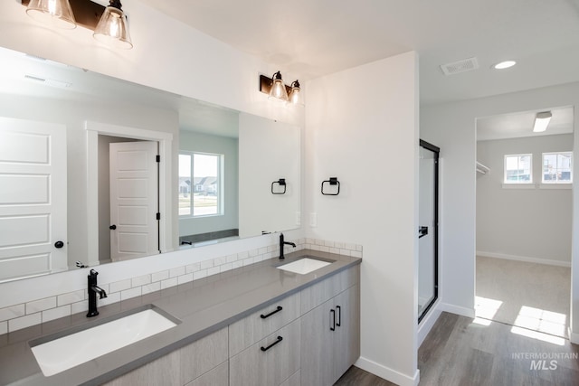 full bath featuring double vanity, a stall shower, visible vents, and a sink