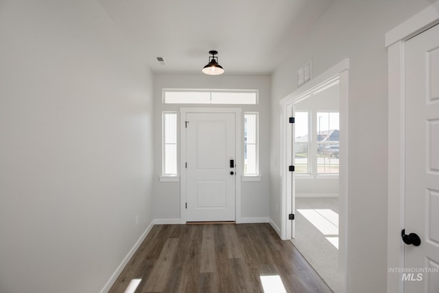 entrance foyer with a wealth of natural light, visible vents, baseboards, and wood finished floors