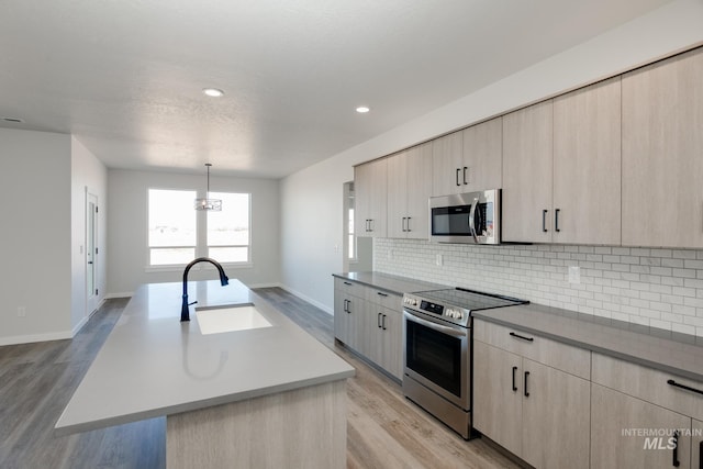 kitchen featuring a sink, modern cabinets, appliances with stainless steel finishes, and light brown cabinets