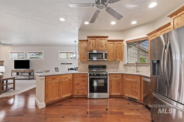 2479 N Devlin Ave, Meridian, ID 83646 - kitchen featuring appliances with stainless steel finishes, ceiling fan, a peninsula, open floor plan, and light countertops