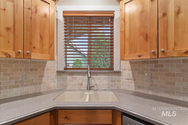 2479 N Devlin Ave, Meridian, ID 83646 - kitchen with a sink, backsplash, light countertops, and stainless steel dishwasher