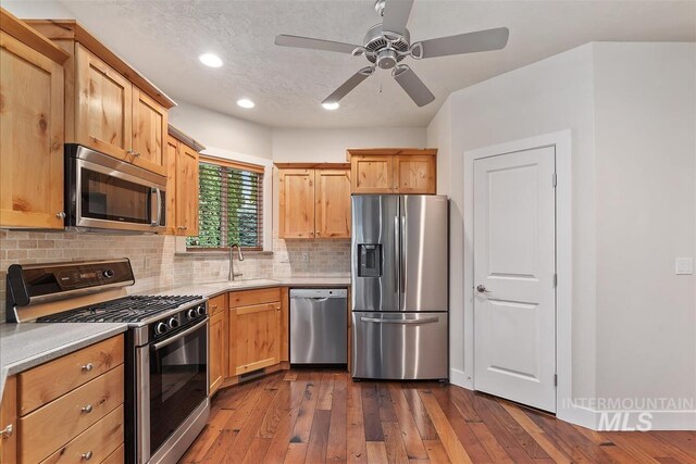 2479 N Devlin Ave, Meridian, ID 83646 - kitchen with appliances with stainless steel finishes, a sink, decorative backsplash, light countertops, and recessed lighting