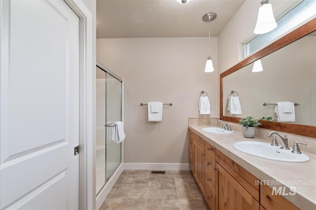 2479 N Devlin Ave, Meridian, ID 83646 - bathroom featuring baseboards, double vanity, and a stall shower