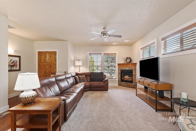 2479 N Devlin Ave, Meridian, ID 83646 - carpeted living area featuring ceiling fan, baseboards, and a stone fireplace