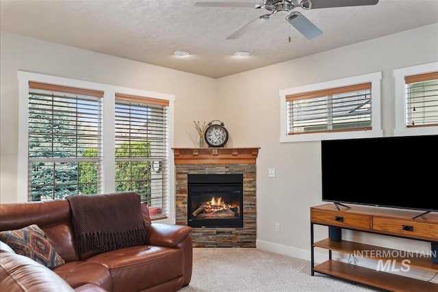 2479 N Devlin Ave, Meridian, ID 83646 - carpeted living room featuring ceiling fan, baseboards, a stone fireplace, and a textured ceiling