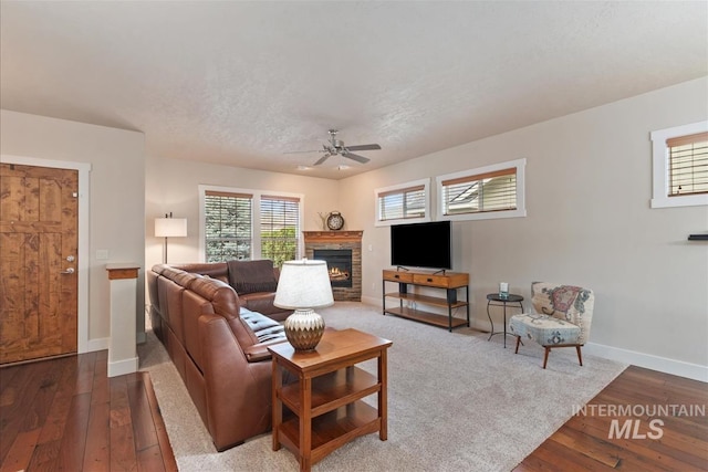 2479 N Devlin Ave, Meridian, ID 83646 - living area with a ceiling fan, baseboards, a lit fireplace, wood-type flooring, and a textured ceiling
