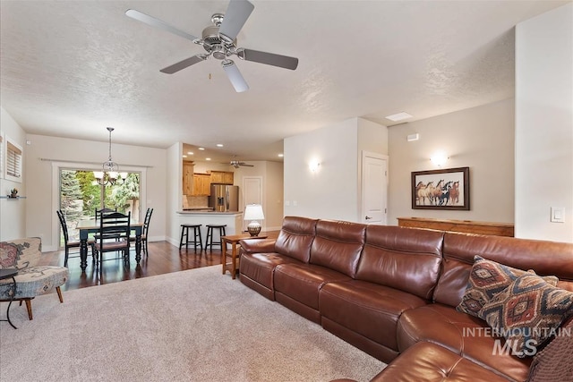 2479 N Devlin Ave, Meridian, ID 83646 - carpeted living area featuring ceiling fan, a chandelier, wood finished floors, a textured ceiling, and baseboards