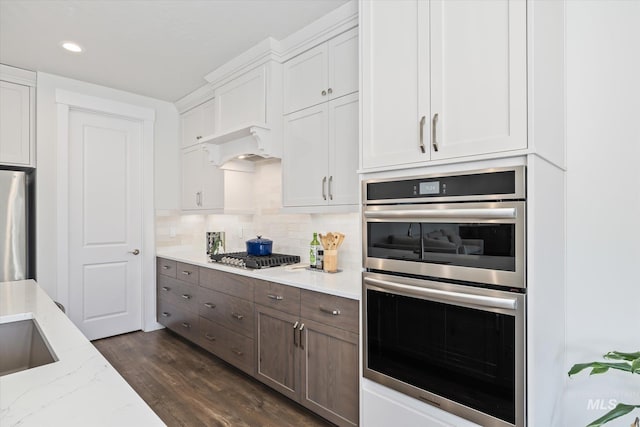 6086 S Sachet Ave, Meridian, ID 83642 - kitchen with white cabinets, dark wood-style flooring, light stone counters, stainless steel appliances, and tasteful backsplash