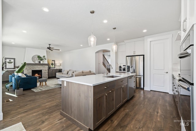 6086 S Sachet Ave, Meridian, ID 83642 - kitchen featuring ceiling fan, a sink, light countertops, arched walkways, and stainless steel appliances