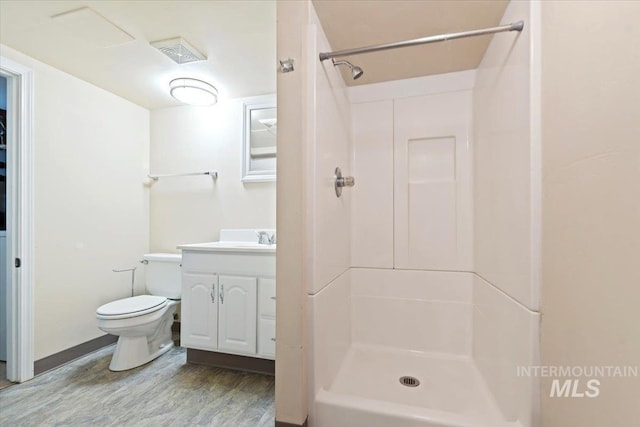 bathroom featuring a shower, toilet, vanity, and hardwood / wood-style flooring