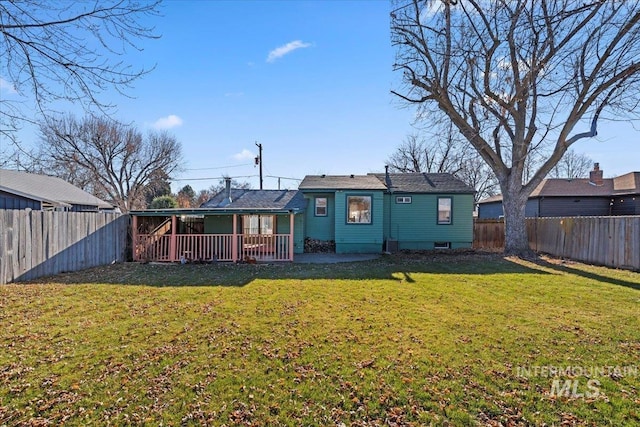 back of house with a lawn and a patio