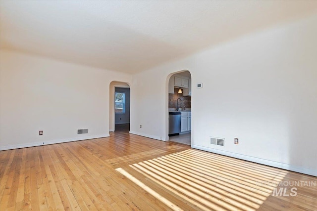 empty room featuring sink and light wood-type flooring