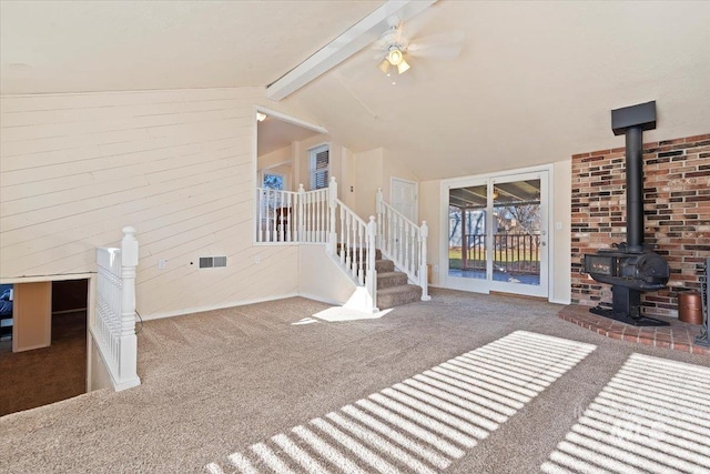 unfurnished living room featuring carpet, lofted ceiling with beams, and ceiling fan