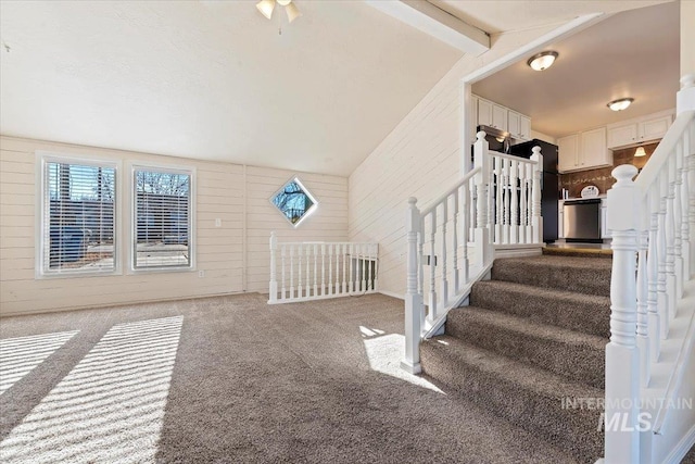 stairway with carpet and lofted ceiling with beams