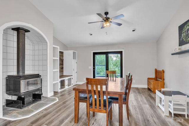 8466 W Idaho Blvd, Letha, ID 83636 - dining space featuring a wood stove, vaulted ceiling, wood finished floors, ceiling fan, and baseboards
