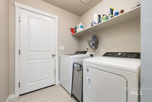 clothes washing area featuring light floors, baseboards, laundry area, and independent washer and dryer