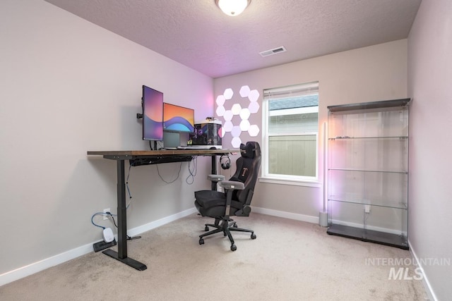 carpeted office space with baseboards, visible vents, and a textured ceiling