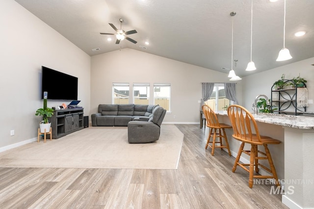 living room with light wood finished floors, baseboards, recessed lighting, lofted ceiling, and ceiling fan