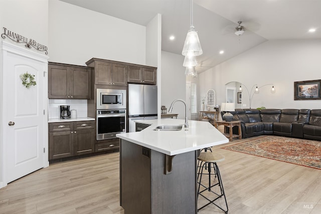 1010 Blueridge Dr, Kimberly, ID 83341 - kitchen featuring stainless steel appliances, high vaulted ceiling, a kitchen breakfast bar, light countertops, and dark brown cabinetry