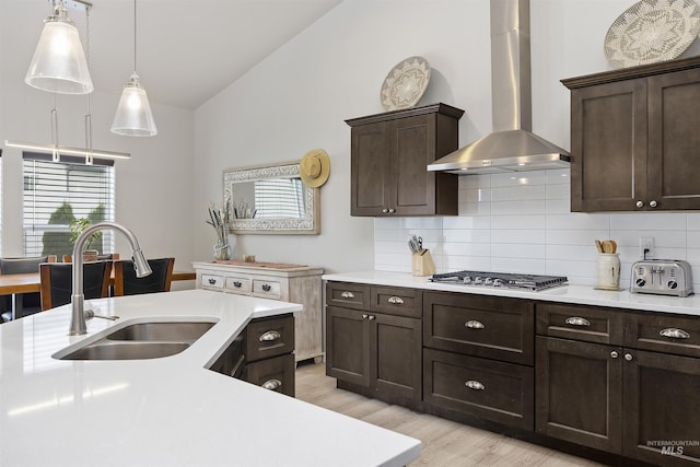 1010 Blueridge Dr, Kimberly, ID 83341 - kitchen with wall chimney exhaust hood, stainless steel gas cooktop, vaulted ceiling, dark brown cabinetry, and decorative backsplash