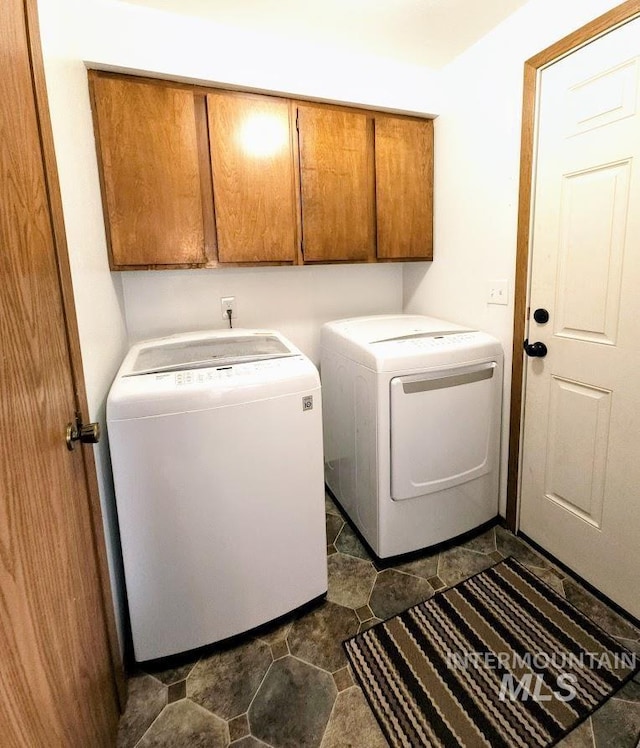 washroom featuring cabinets and washer and clothes dryer