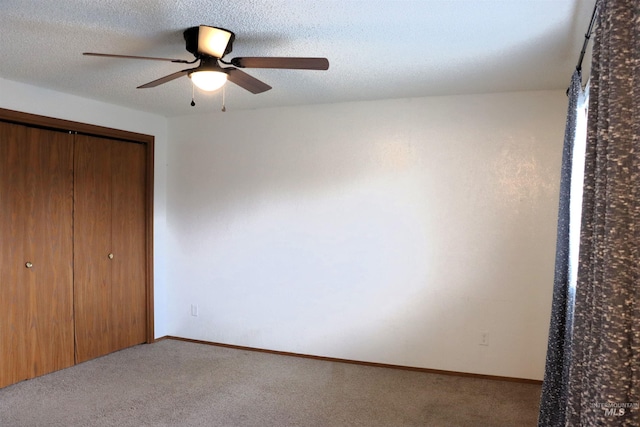 unfurnished bedroom with ceiling fan, light colored carpet, a textured ceiling, and a closet