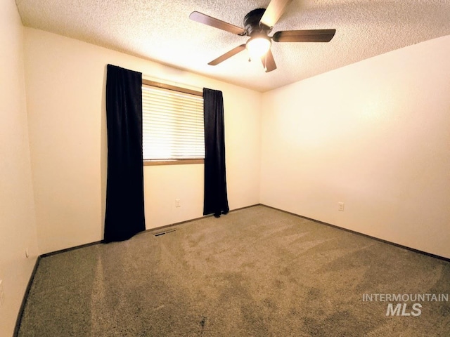 carpeted empty room with a textured ceiling and ceiling fan