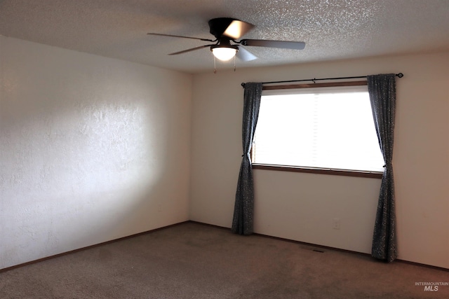 empty room featuring ceiling fan, a textured ceiling, and carpet floors