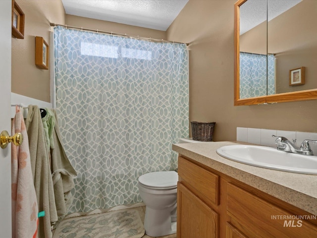bathroom featuring toilet, vanity, and a shower with shower curtain